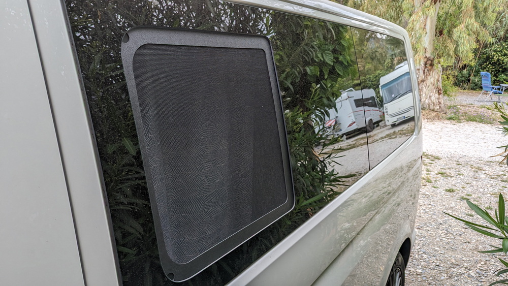 Weißer T5 von der Seite. Das Seitenfenster ist offen und vom Moskitonetz voll abgedeckt.